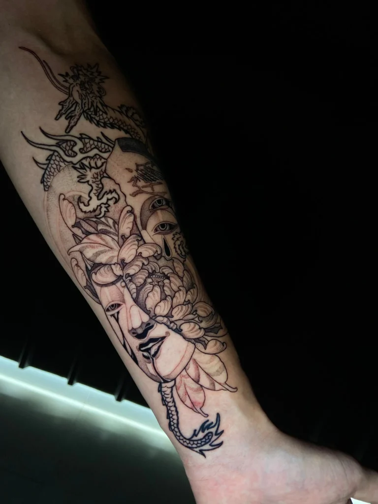 Tatuaje estilo japonés en antebrazo con dragón y máscara ornamental, realizado en Black Drip Studio Valencia.