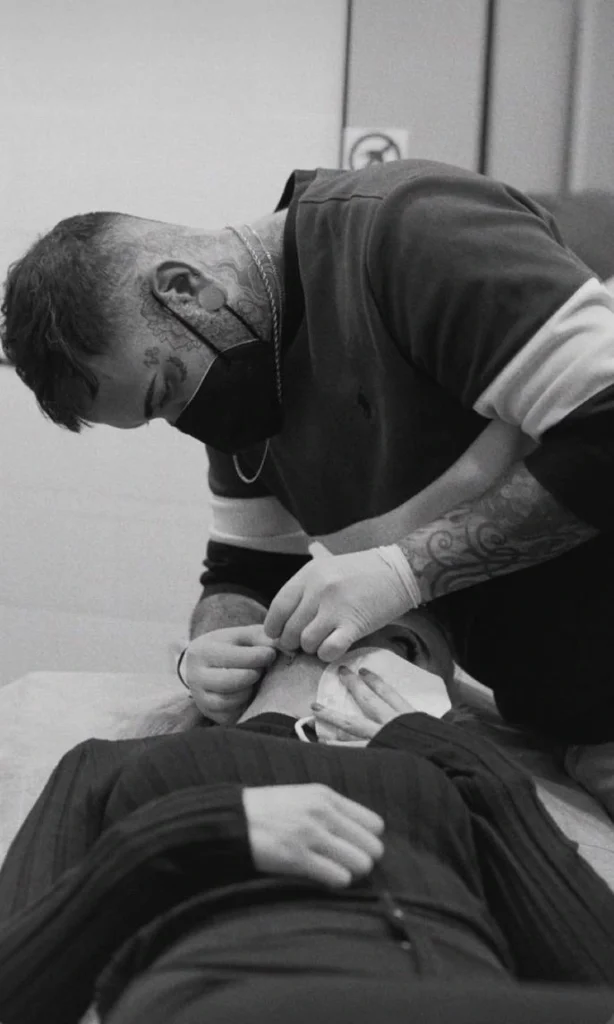Profesional de piercings en Valencia realizando la colocación con guantes y esterilización en BlackDrip Studio.